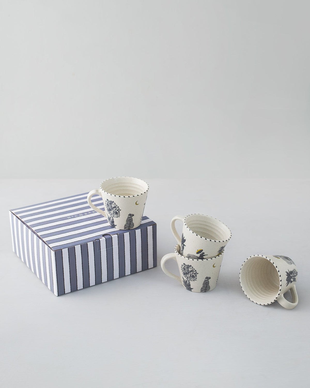 Haathi Sher Espresso Mug set of four beside a navy striped gift box.