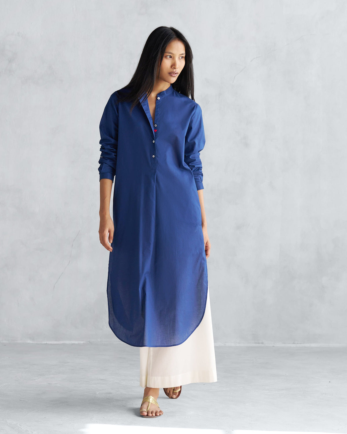 Person wearing a navy long kurta with a mandarin collar and curved hem.