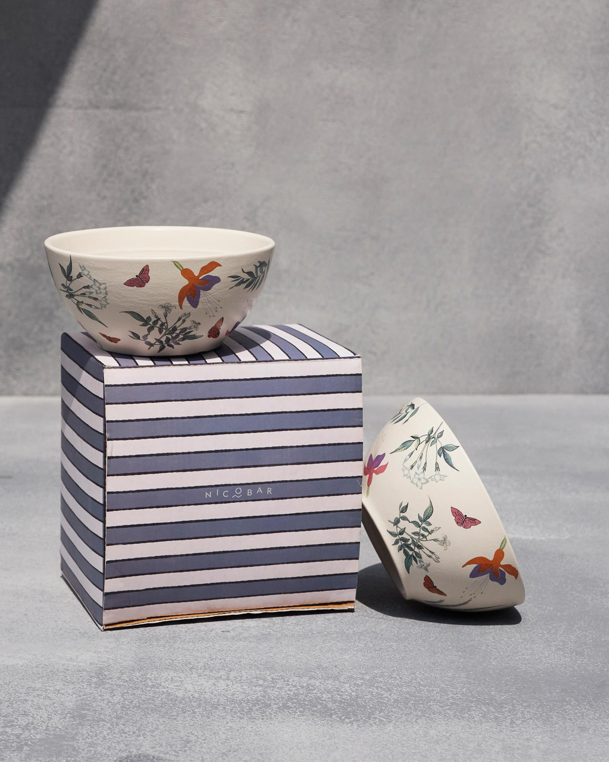 Botanical Cereal Bowl set on a striped box beside a second bowl.