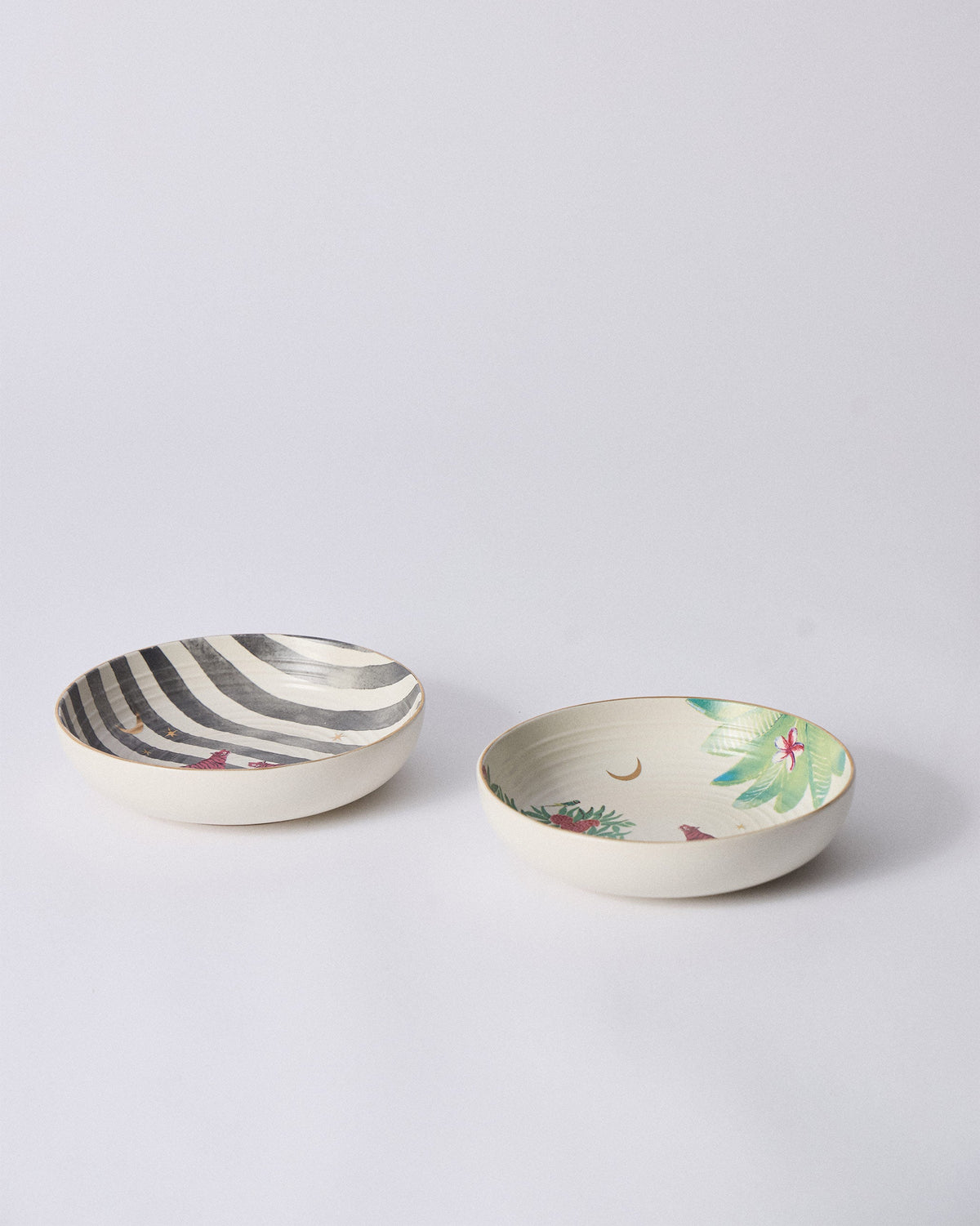 Pair of Ceylon Trail Shallow Bowls with striped and palm interiors.