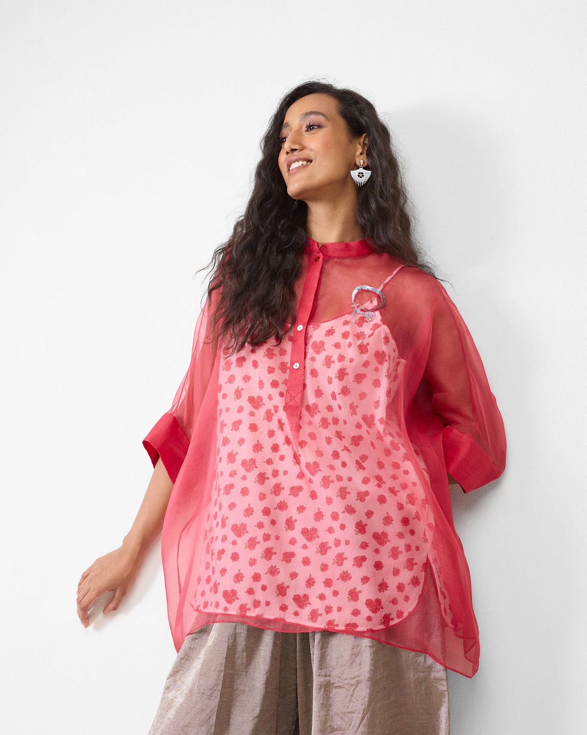Person wearing a sheer watermelon shirt over a floral slip.