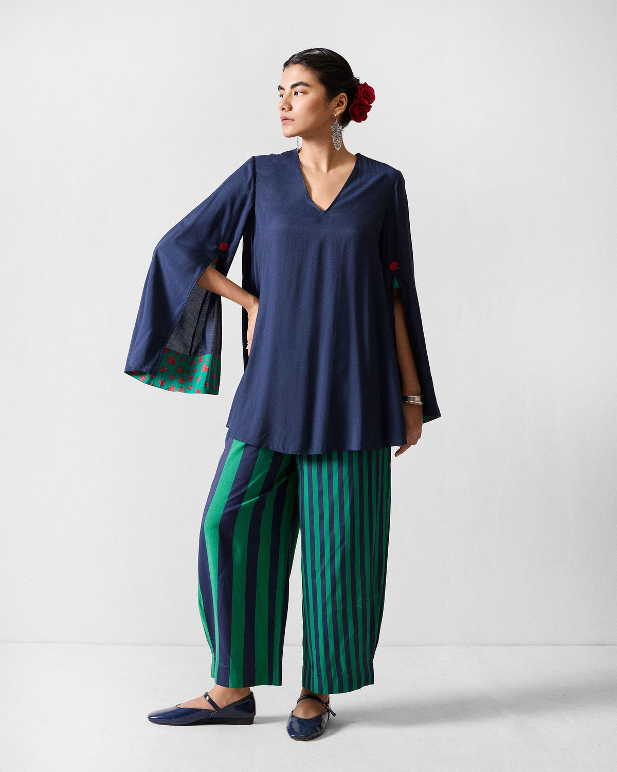 Person wearing navy and green striped Serene pants with a matching navy tunic.