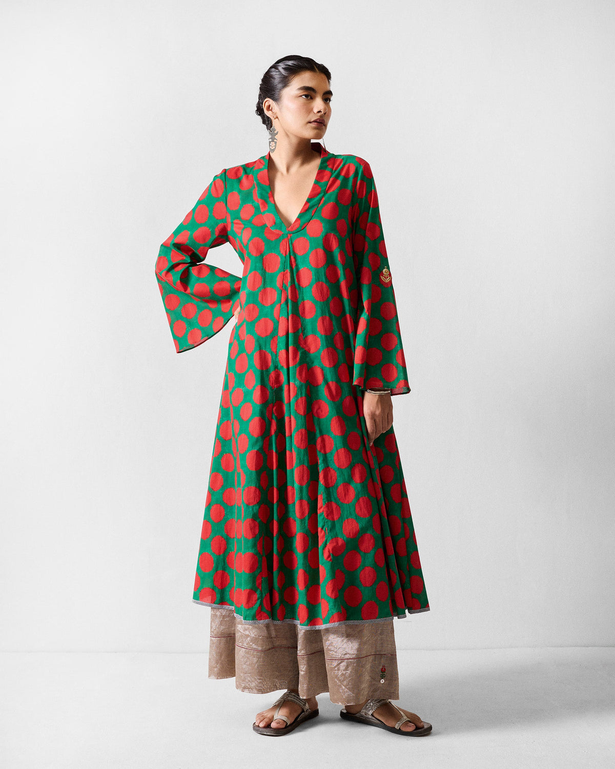 Person wearing a green Talas kurta with large red dots and flared sleeves.