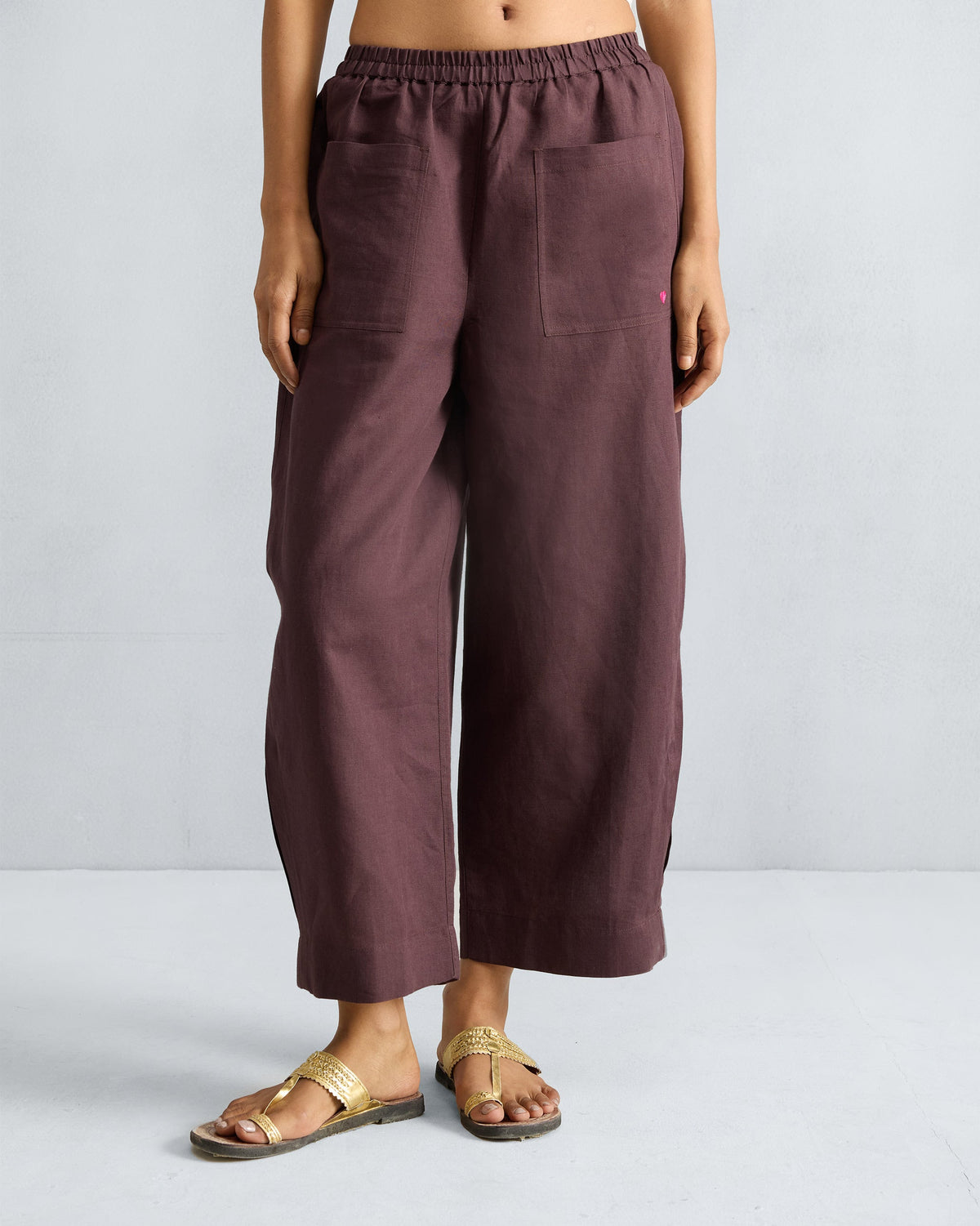 Person wearing chocolate plum Serene pants with front patch pockets.