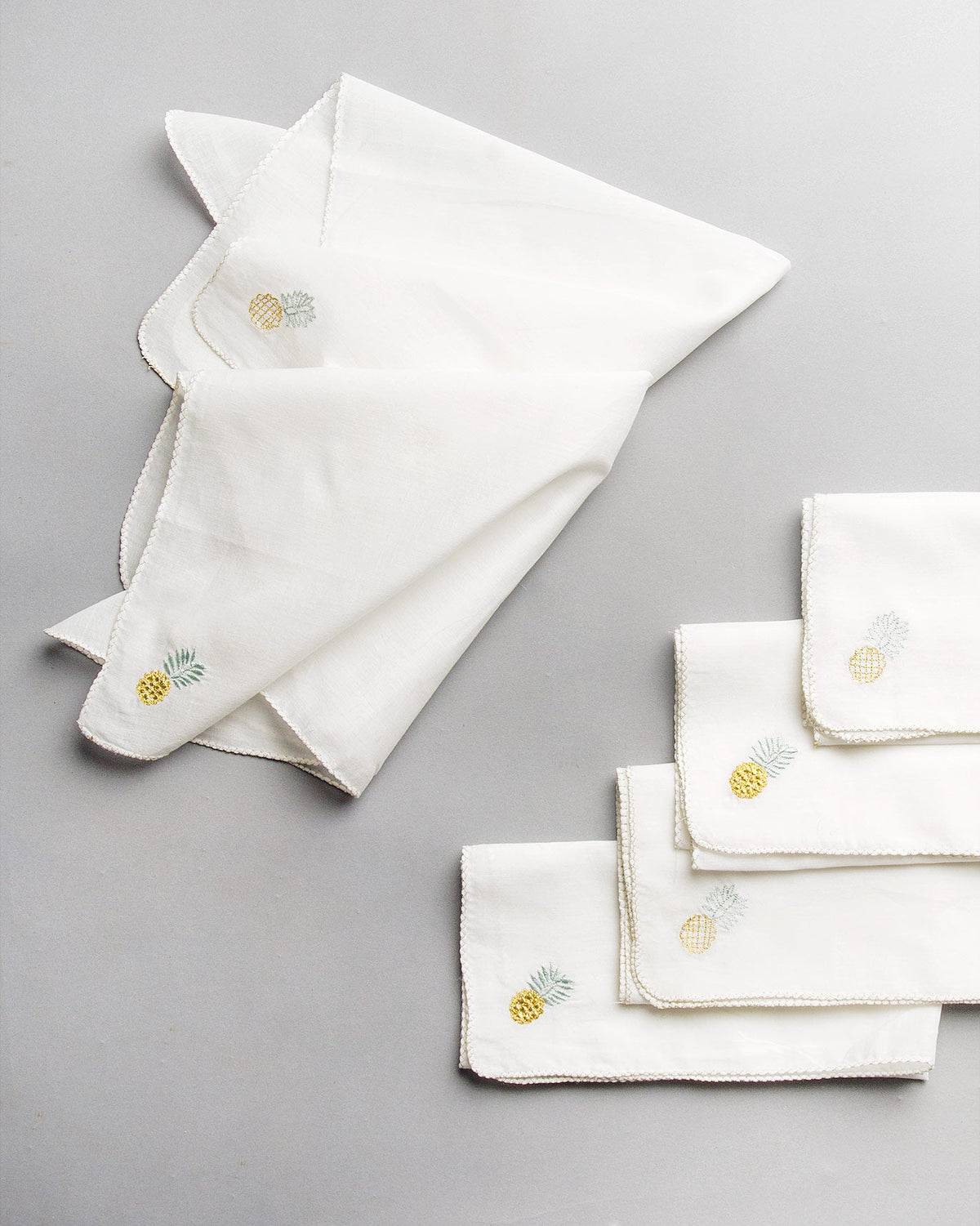 Chin-Chin Pineapple Napkins stacked with a pineapple embroidered in each corner.