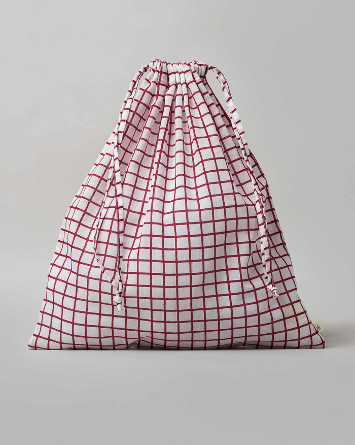 Check Wear Bag with a red grid check and drawstring closure.