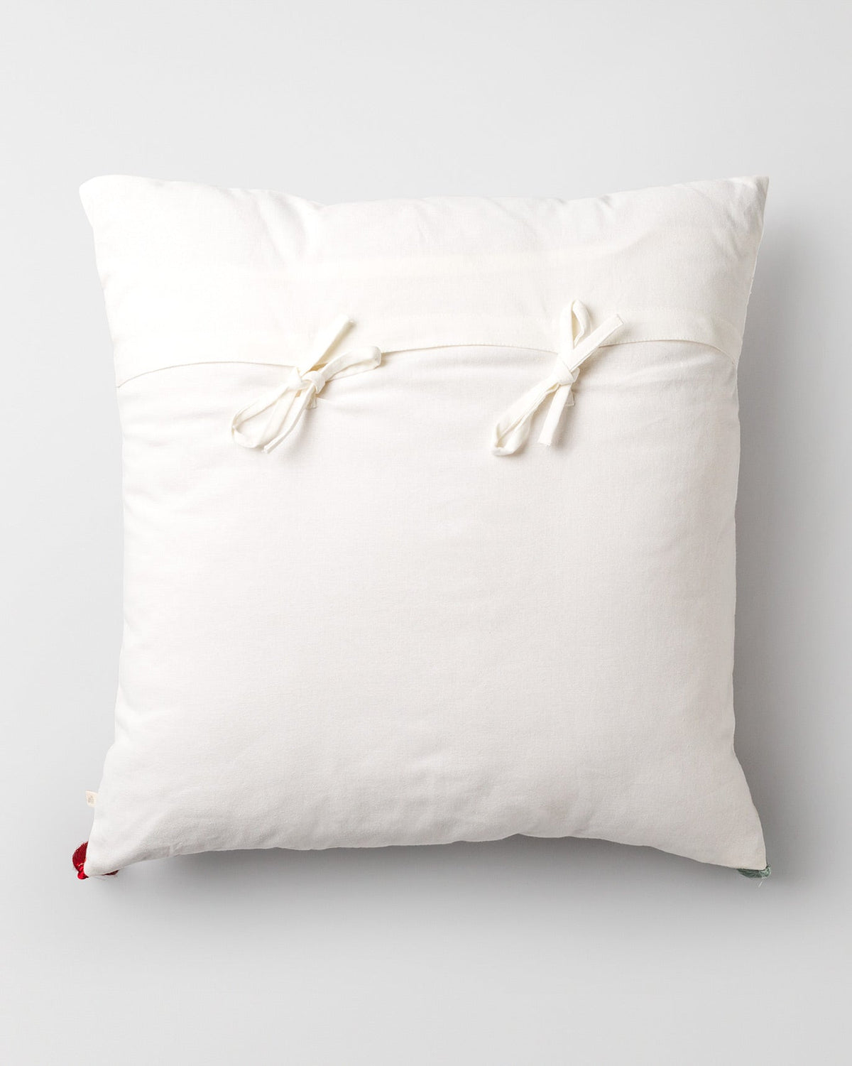 Back of a cream Chi Cushion Cover with tie bows.
