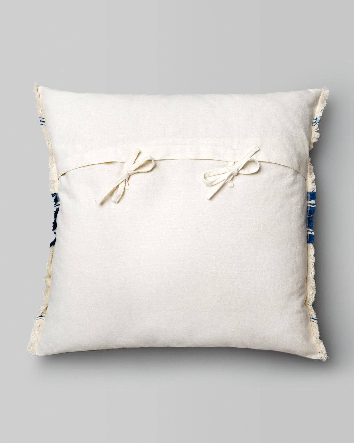 Back of the Kemuri French Stripe Cushion Cover in plain cream with two tie bows.