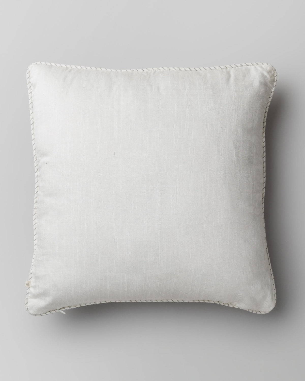 Back of Sakura Cushion Cover in plain cream with a piped edge.