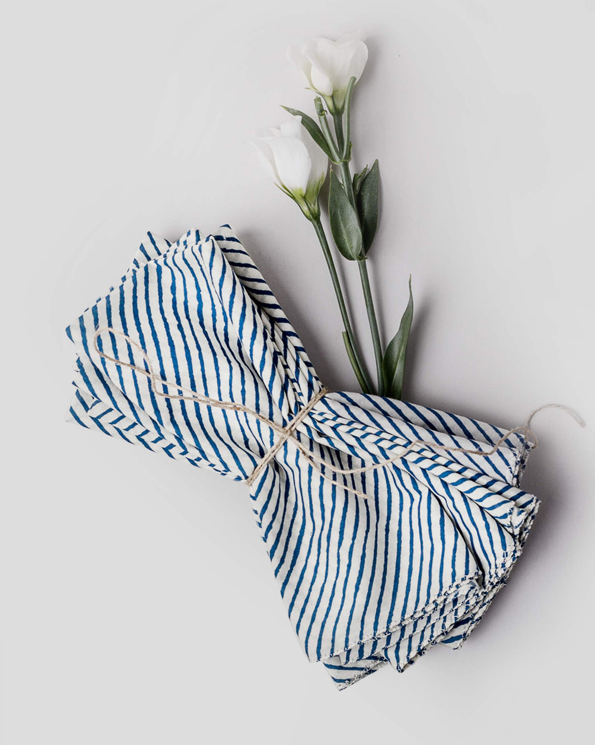 Aozora Stripe Dinner Napkins in dark blue, tied in a bundle with twine.