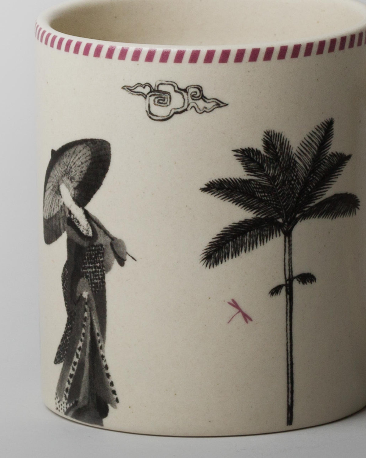 Close-up of Misaki Mug showing a palm tree and a figure in a wide hat.