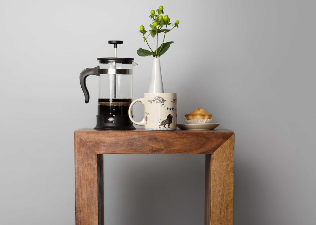 Raion Lion Mug on a wooden stand, showing its black lion print.