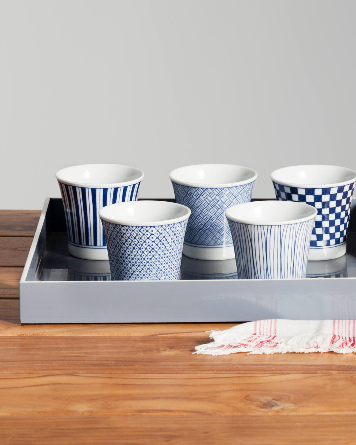 Sencha tea cups in blue and white patterns on a grey tray.