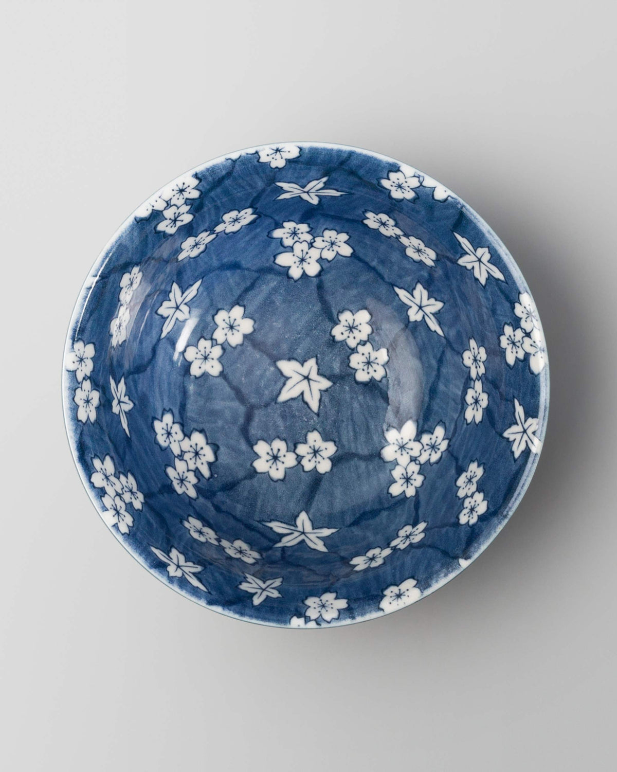 Top view of Sakura Snack Bowl showing white blossoms on a blue interior.