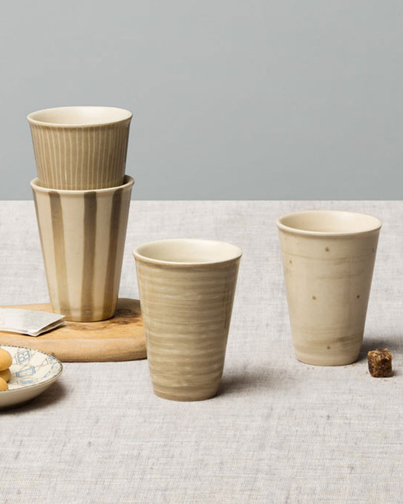 Set of four Nomu Kulhar cups on a linen tabletop.