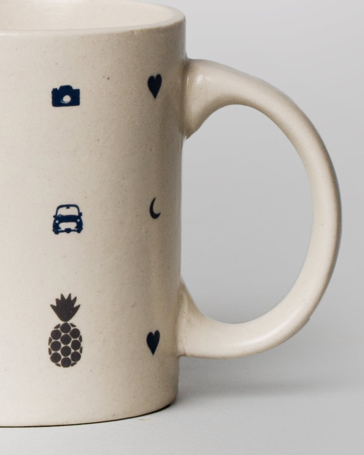 Close-up of the Icon Mug's blue camera, car and pineapple icons.