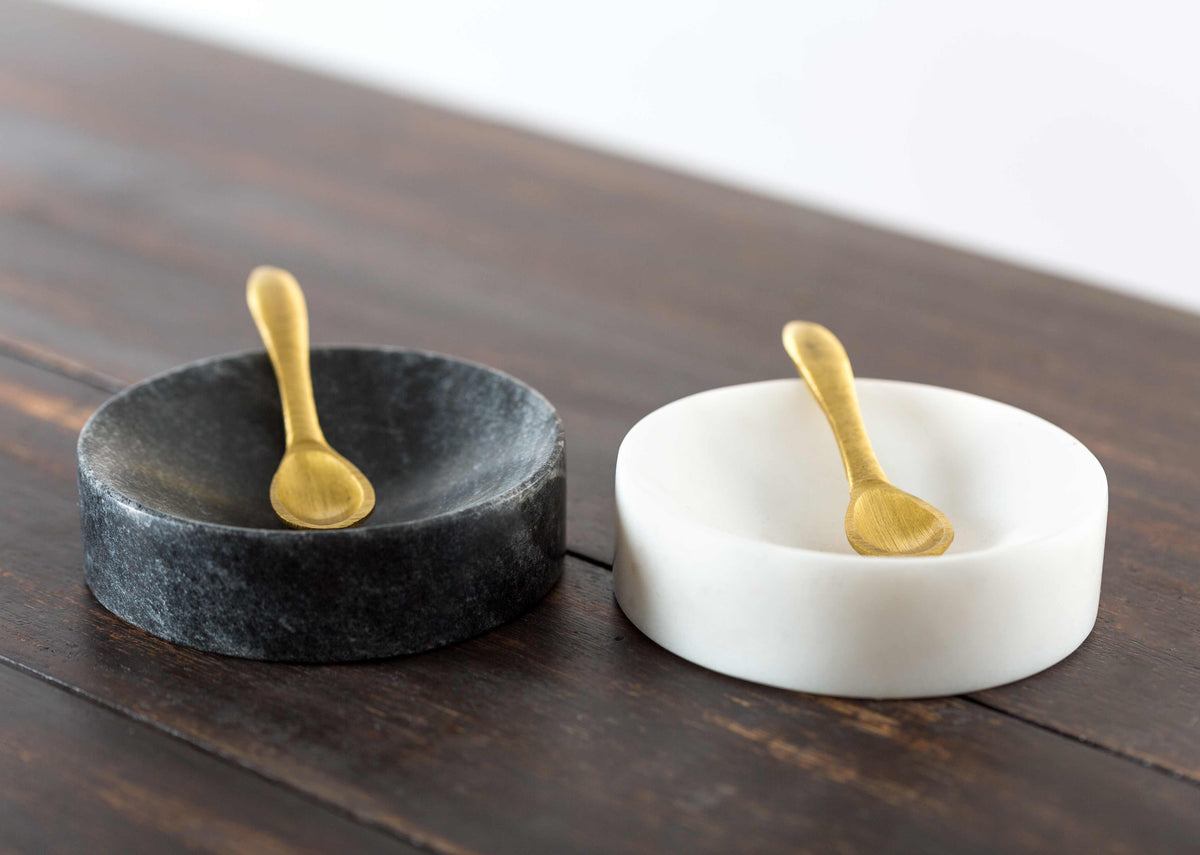 Side view of the Ceylon Pinch Pot Set's black and white dishes with gold spoons.