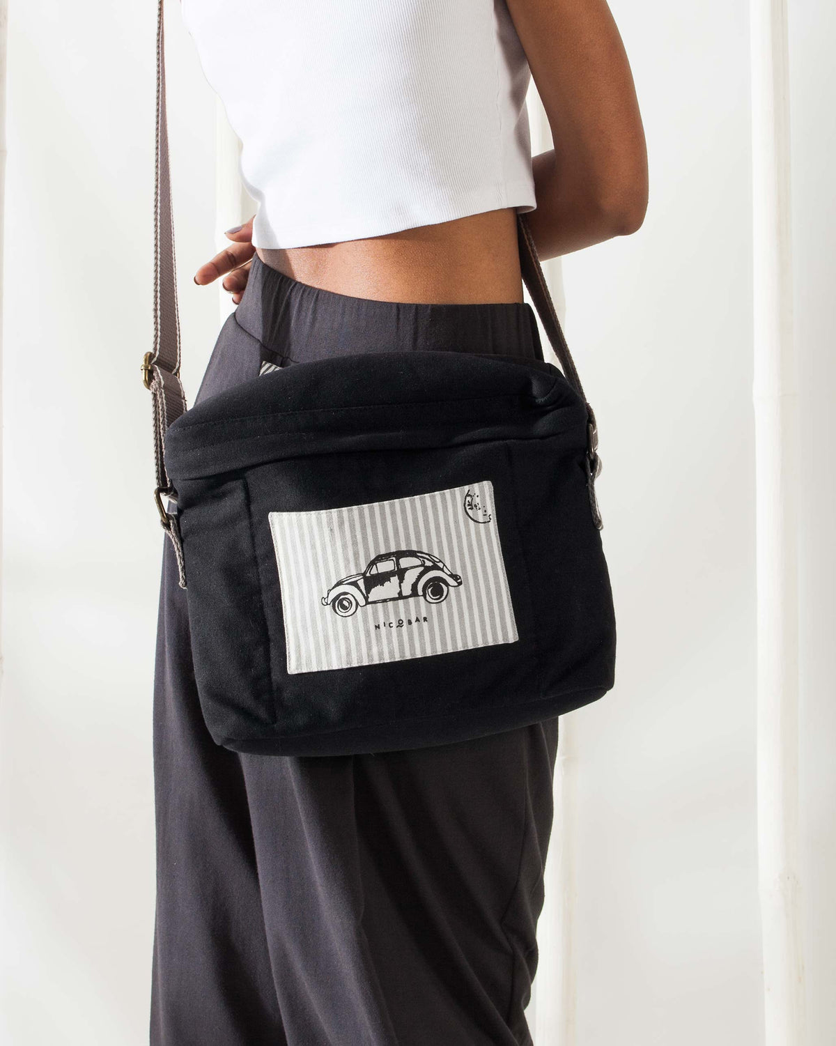 Person wearing the Munchies & Byob Bag on the hip, in black with a cream panel.