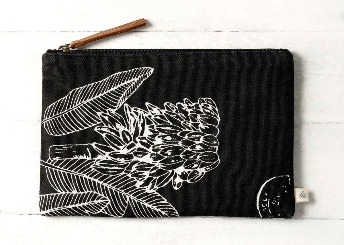 Midi Ele Pouch laid flat, with white botanical line art on black.