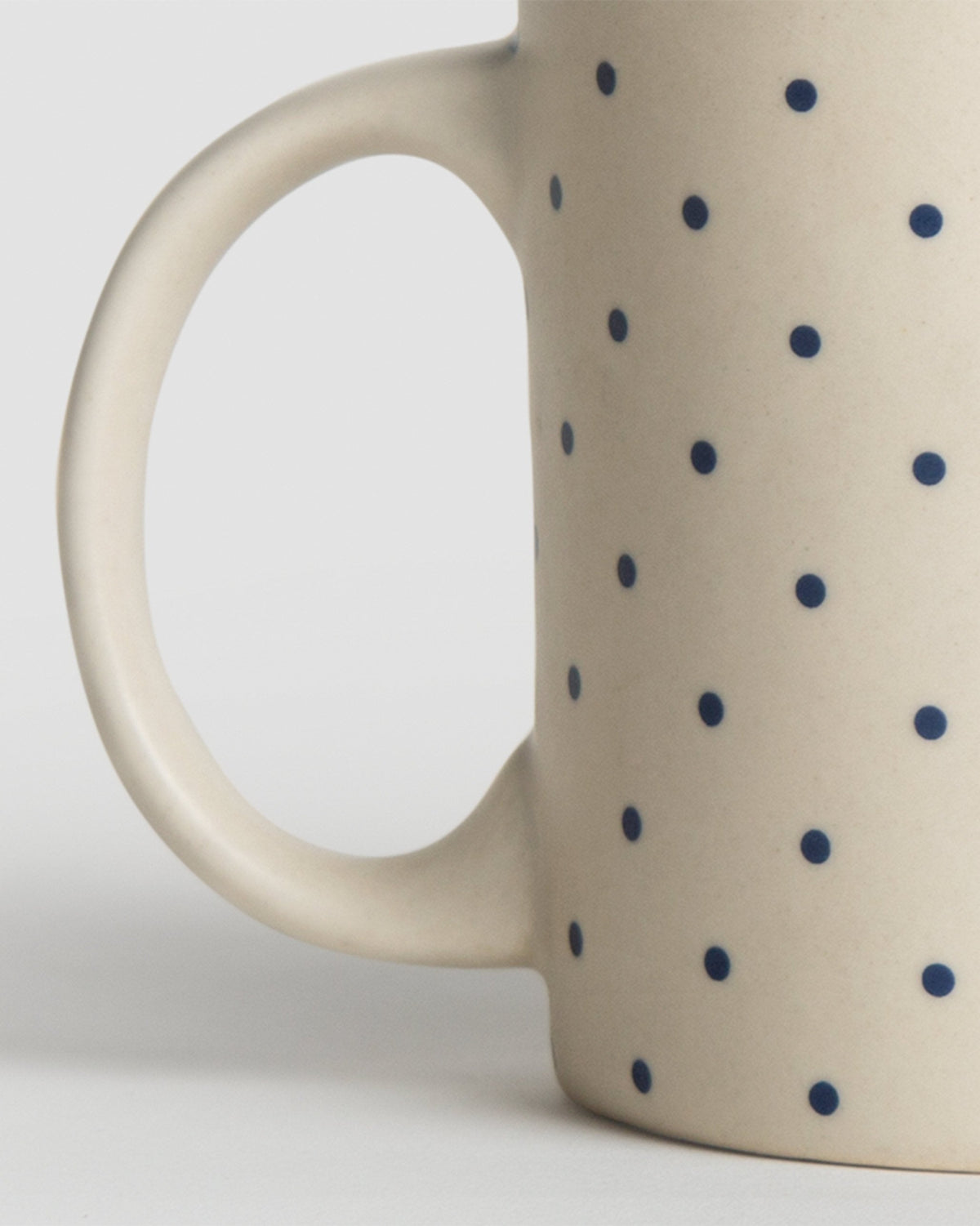Close-up of the Kumarakom polka dot mug showing its handle and navy dots.
