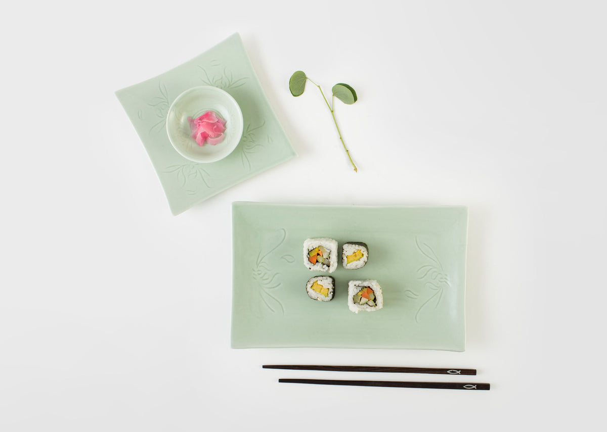 Celadon Sushi Platter set with sushi rolls and chopsticks, beside a small celadon plate.