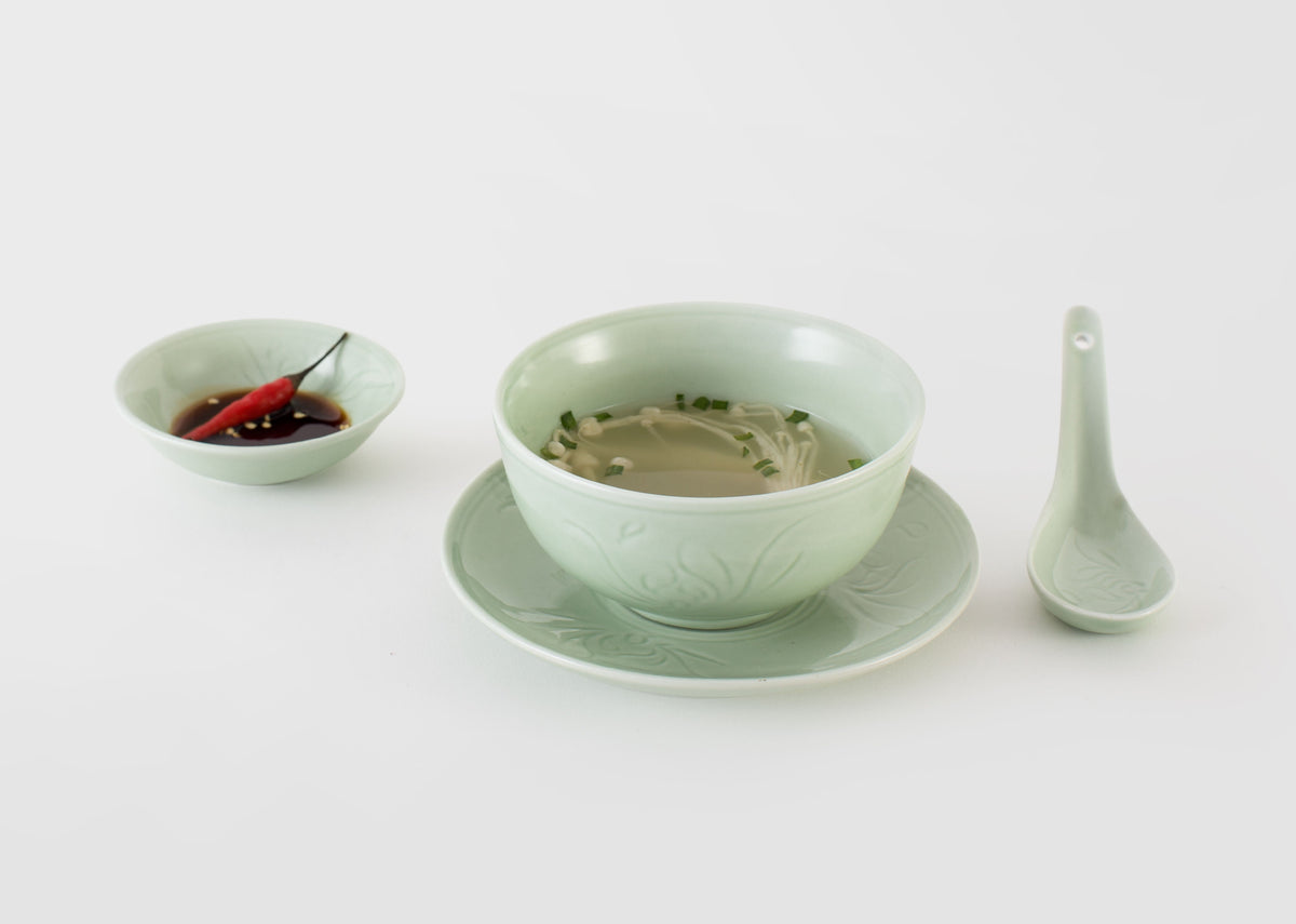 Celadon Wasabi Nut Bowl holding a red chilli, beside a celadon bowl and spoon.
