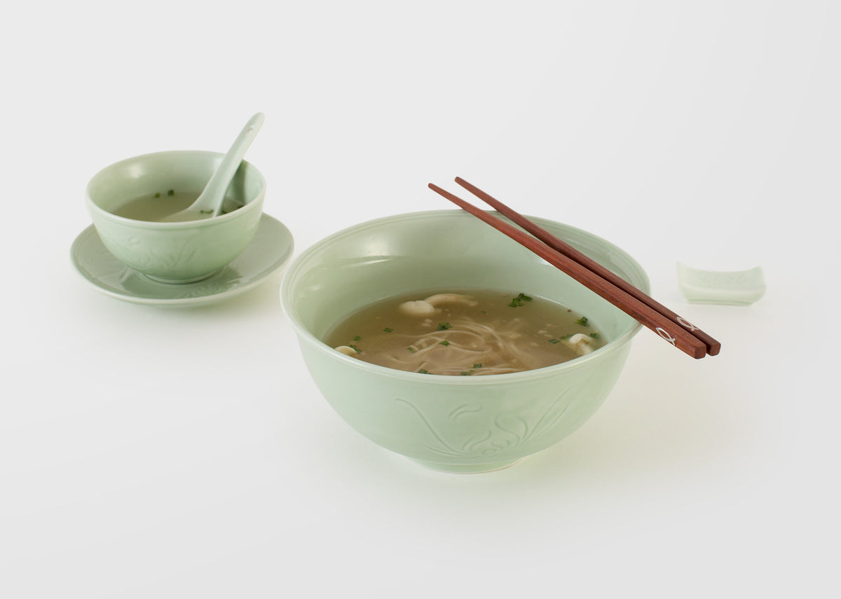 Celadon Noodle Bowl filled with broth, with a small celadon bowl and spoon nearby.