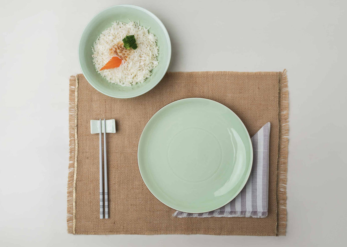 Celadon Dinner Plate in a table setting with a bowl of rice and chopsticks.