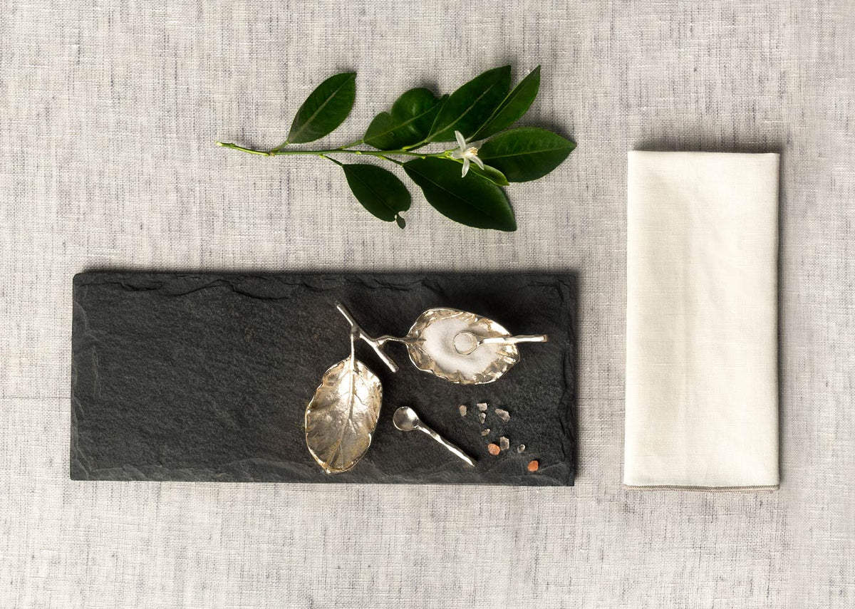 Leaf Pinch Pot and spoons on a black slate board, seen from above.