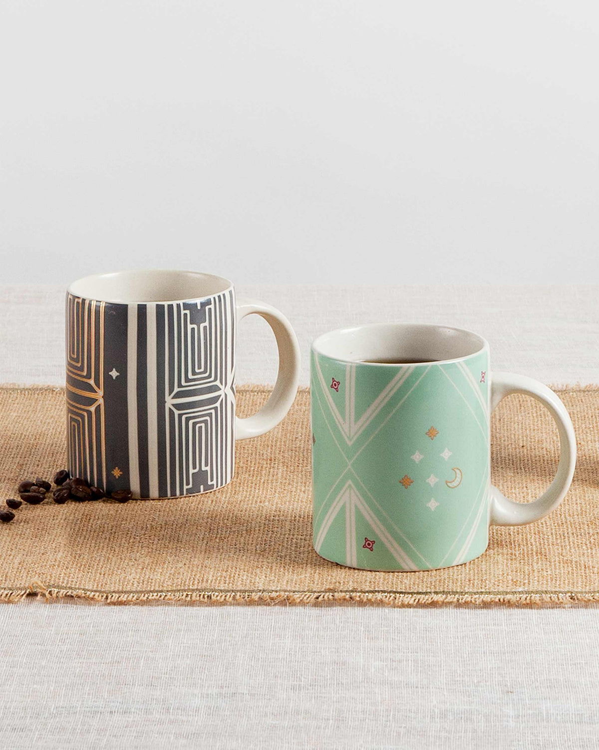 Chand Mug in mint, placed beside a black and white patterned mug.