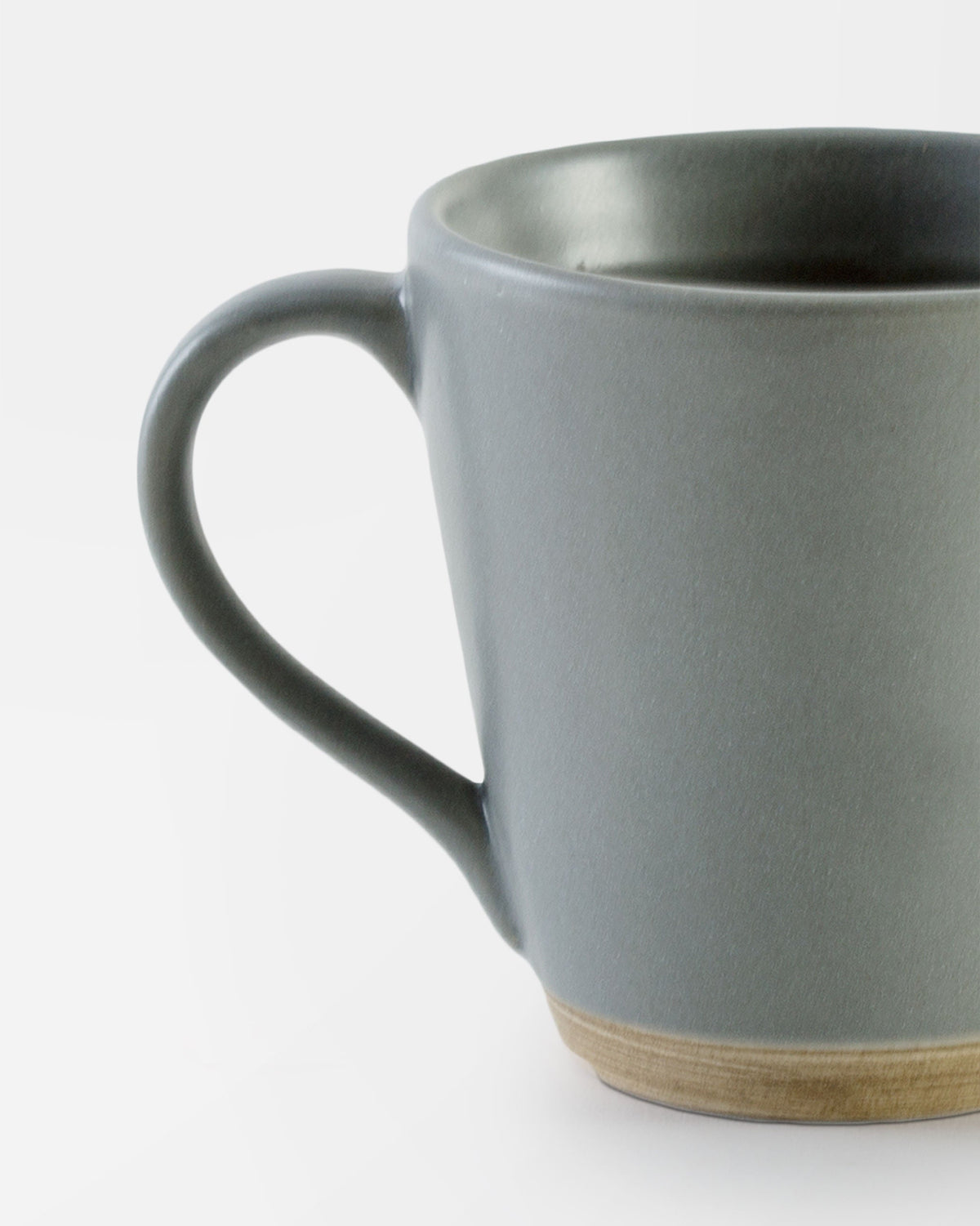 Close-up of the Basalt Mug showing its handle and natural clay base.
