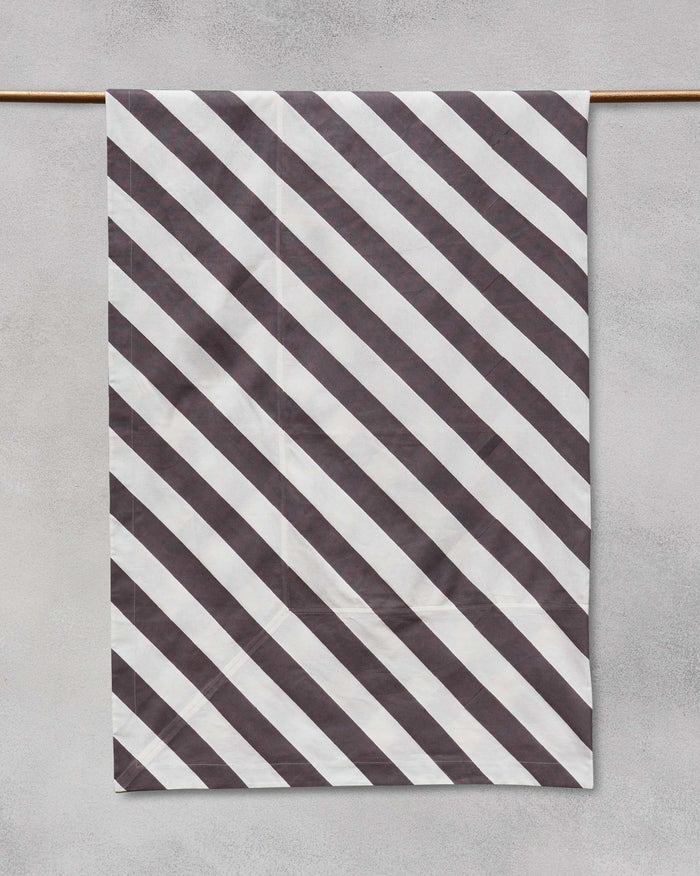 Verandah candy stripe table cloth hanging from a rod.