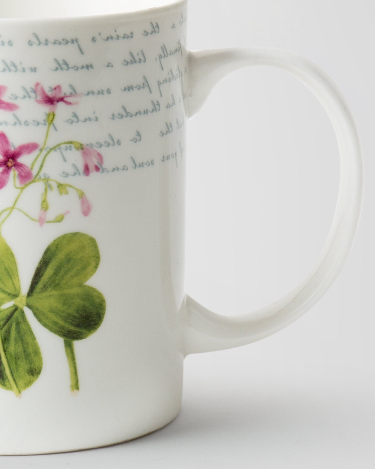Close-up of Botanical Script Mug showing pink flowers, a green leaf and the handle.