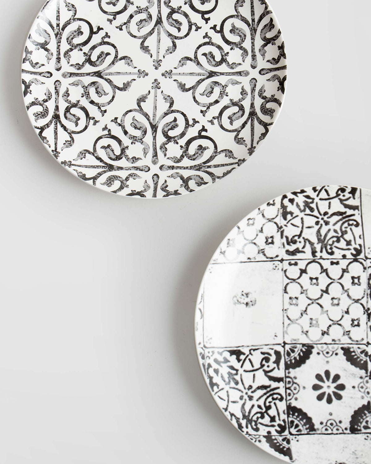 Close-up of Flora Fauna Quarter Plates showing their black tile-style patterns.