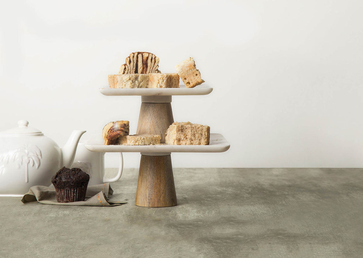 Marble & Wood Cake Stand - Small with two marble tiers holding cake slices.