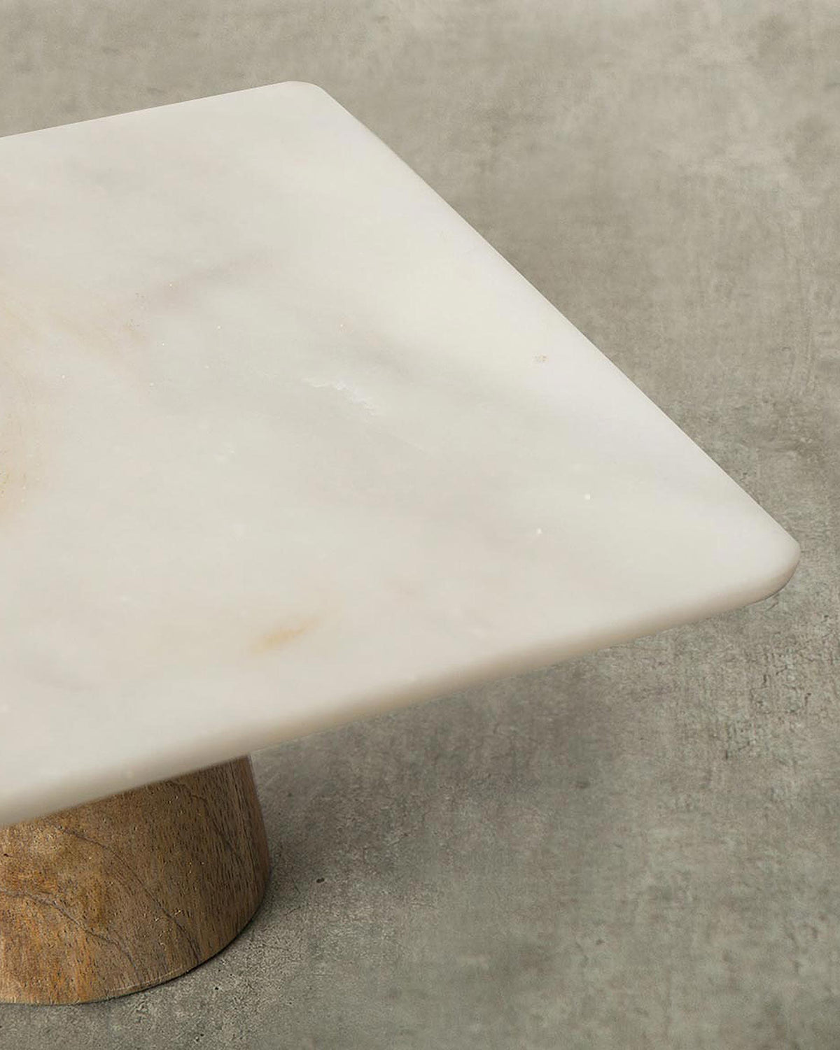 Close-up of Marble & Wood Cake Stand - Small showing the marble top and wooden base.