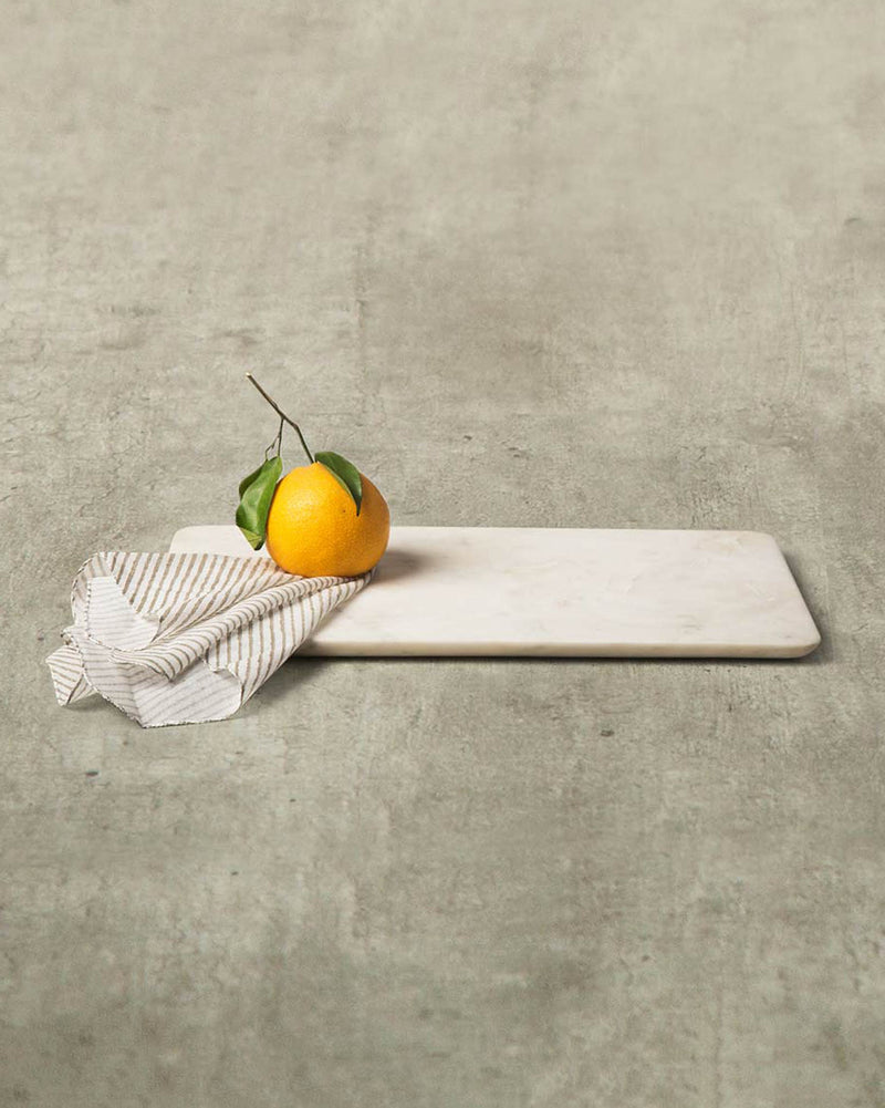 Marble Cheese Board with an orange resting on a striped napkin.