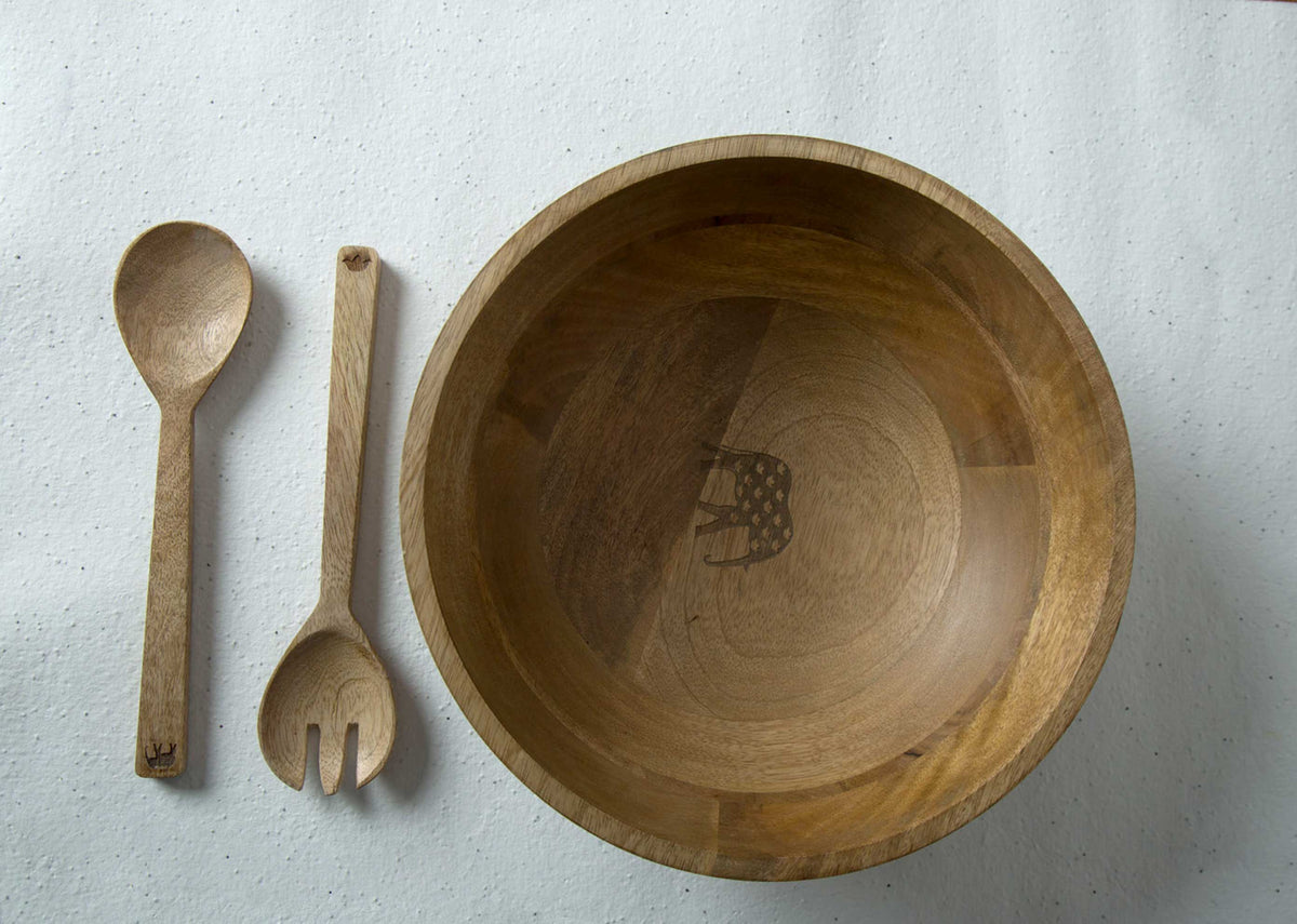 Ele Palm Salad Servers (Set of 2) laid beside a large wooden bowl, seen from above.