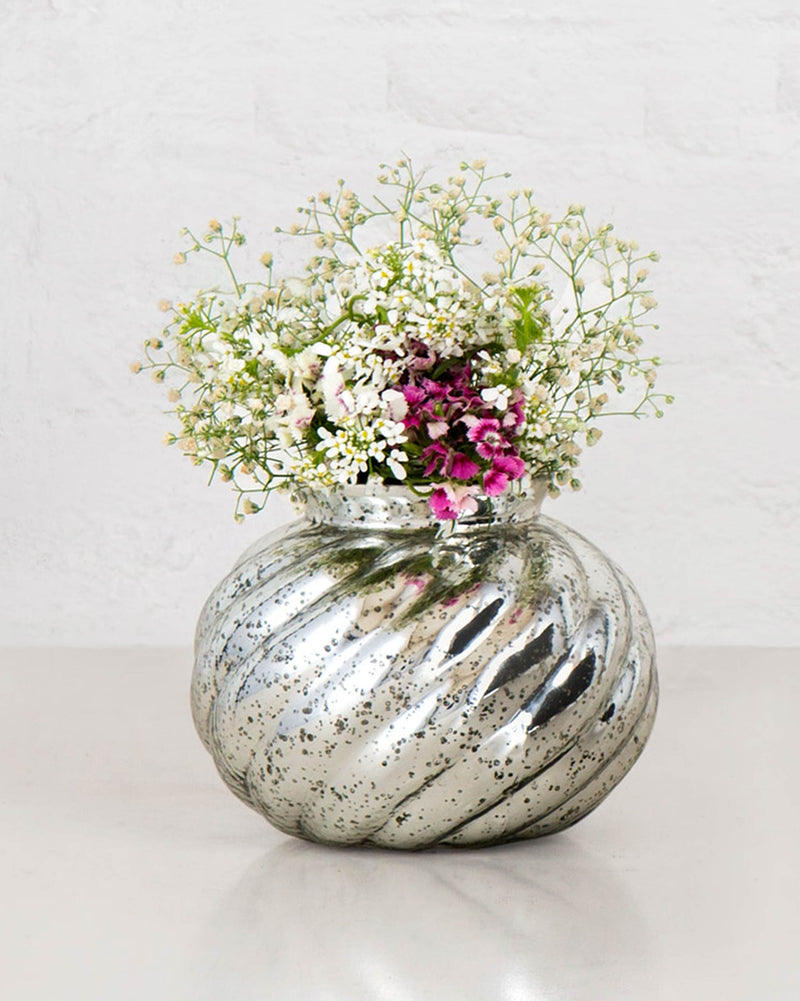 Andromeda Lota Vase in swirled speckled silver glass holding white and pink flowers.
