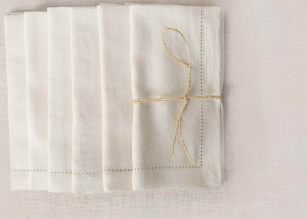 Ivory Verandah dinner napkins fanned out from above and tied with string.