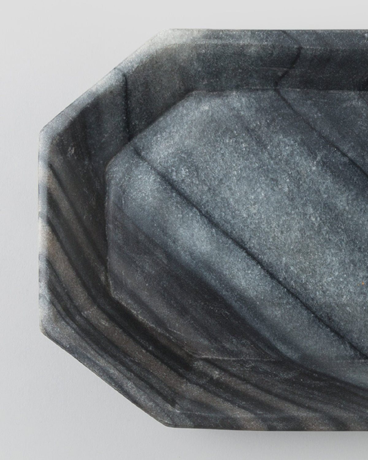 Close-up of the Bagua Tray's faceted corner showing its streaked grey finish.