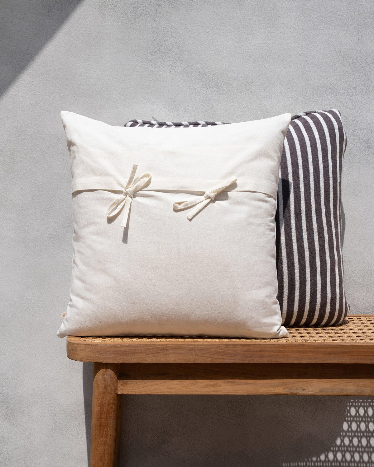 Ele Palm Cushion Cover in cream with fabric tie bows across the centre.