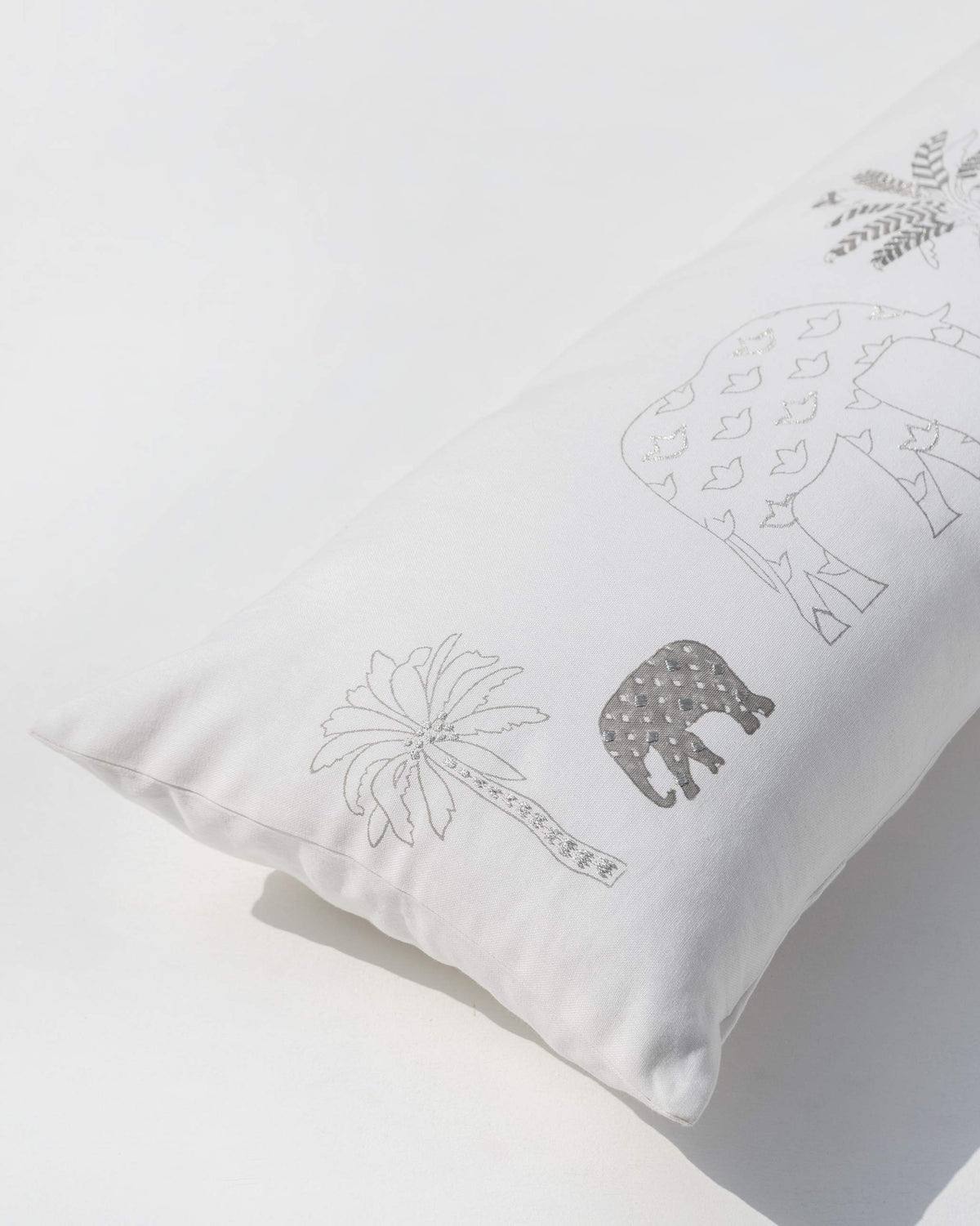 Close-up of Ele Palm Pillow Cover at an angle, showing an outlined elephant and palm tree.