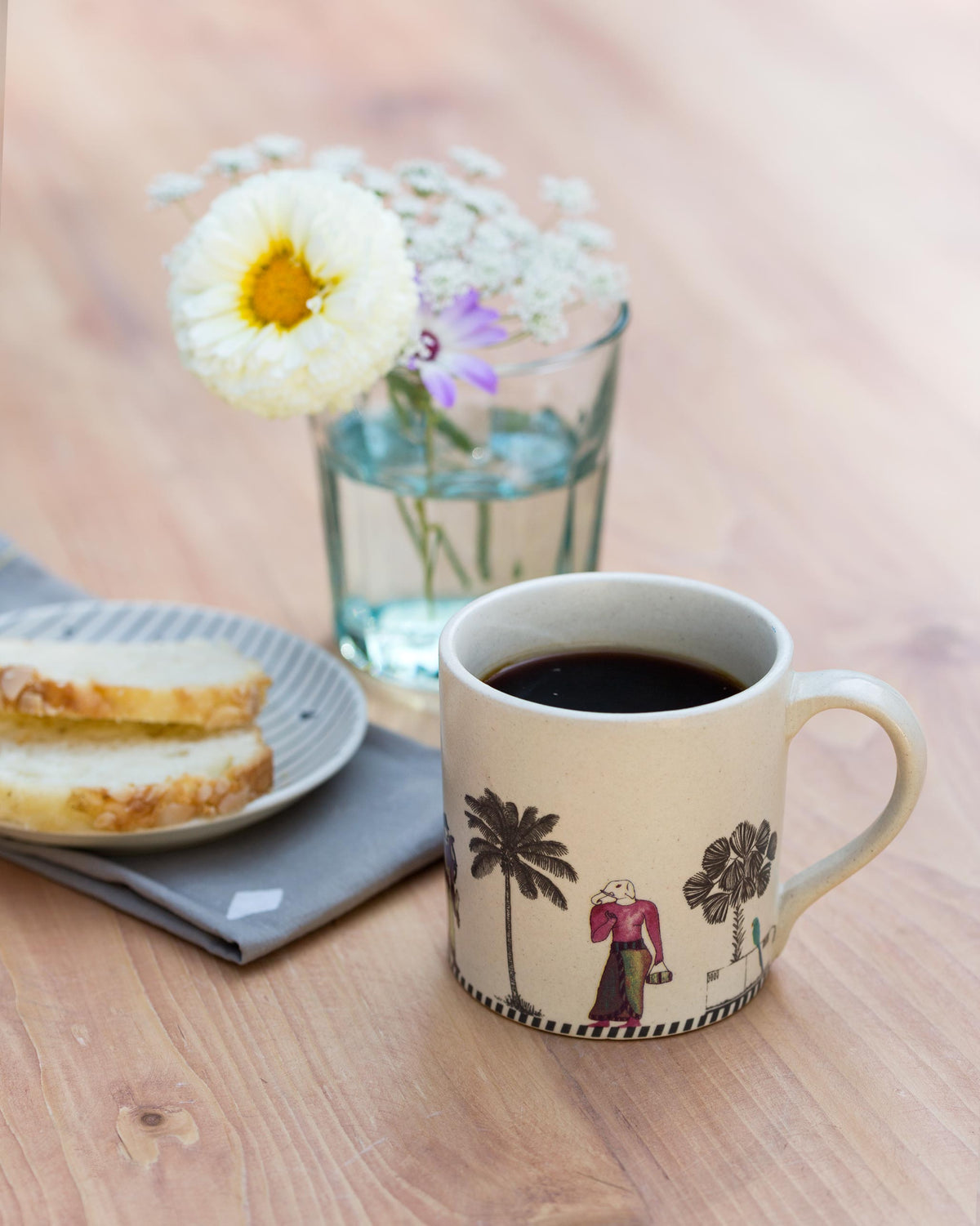 Amman Mug filled with coffee, with a palm tree and printed figure on its side.