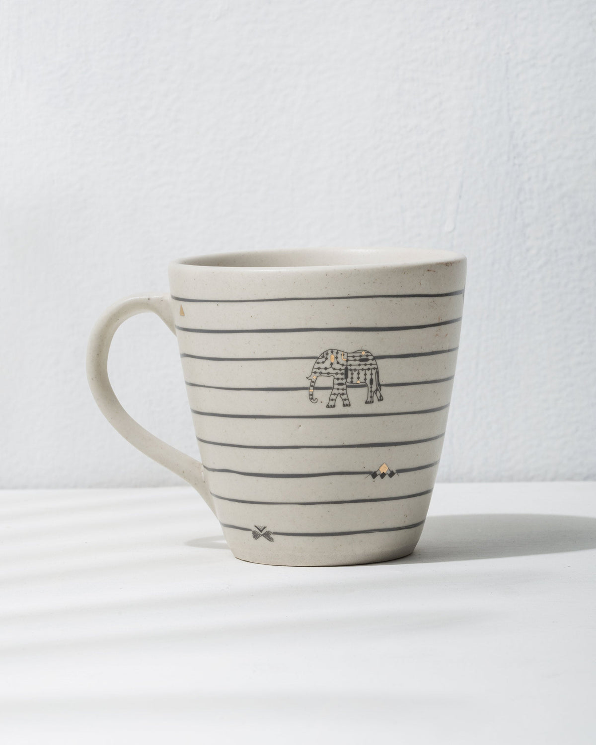 Close-up of the Ceylon conical mug with an elephant motif and small diamond marks.