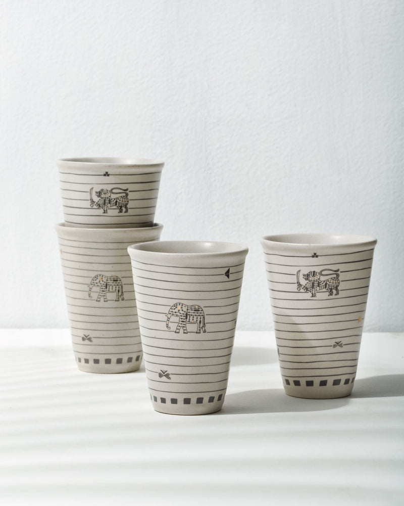 Set of four Ceylon kulhar cups with black elephant motifs and horizontal lines.