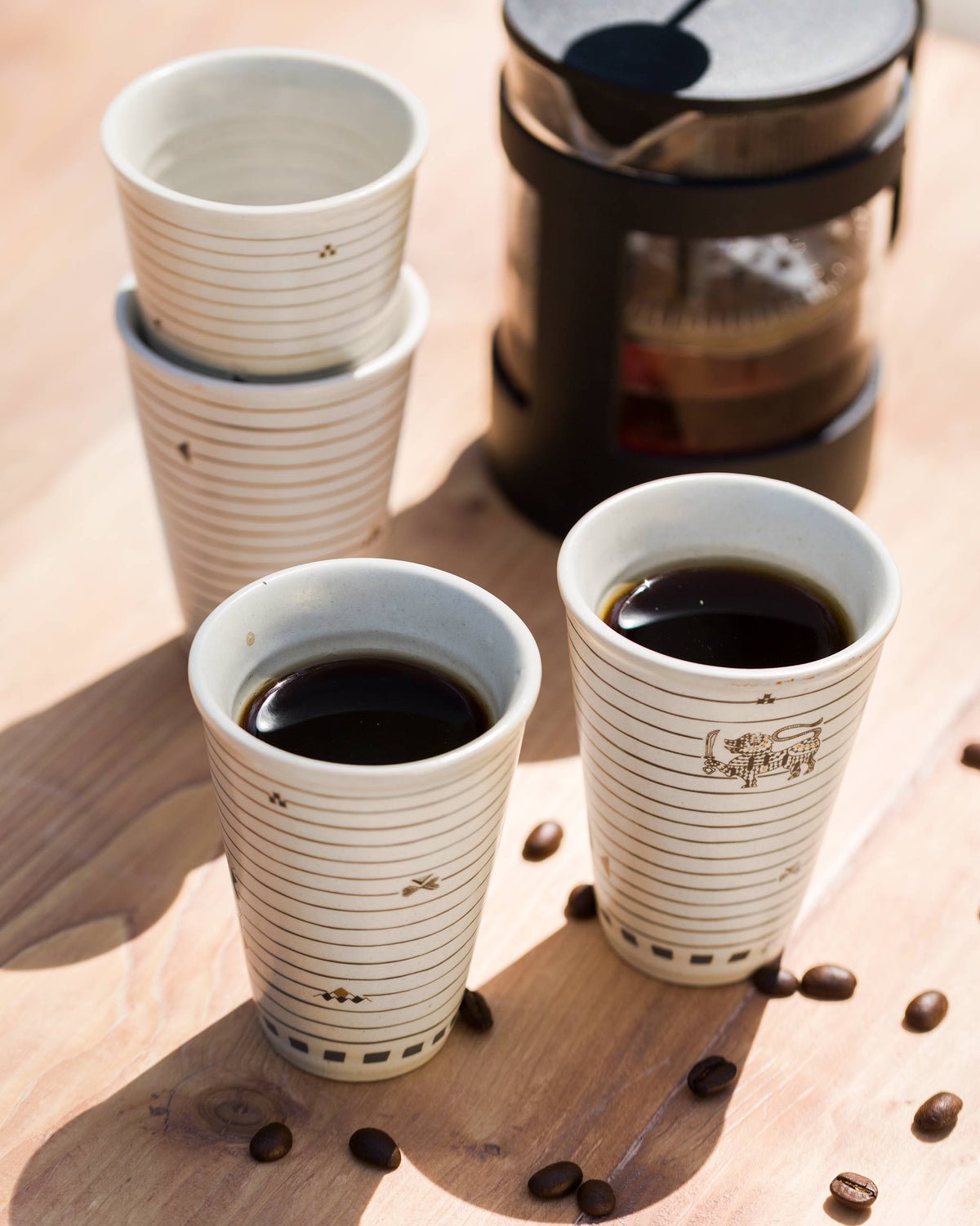 Ceylon Kulhar cups filled with coffee on a wooden table.