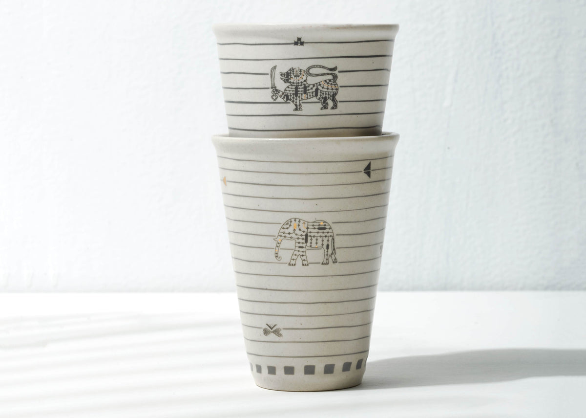 Two Ceylon Kulhar cups stacked, with black motifs and horizontal lines.