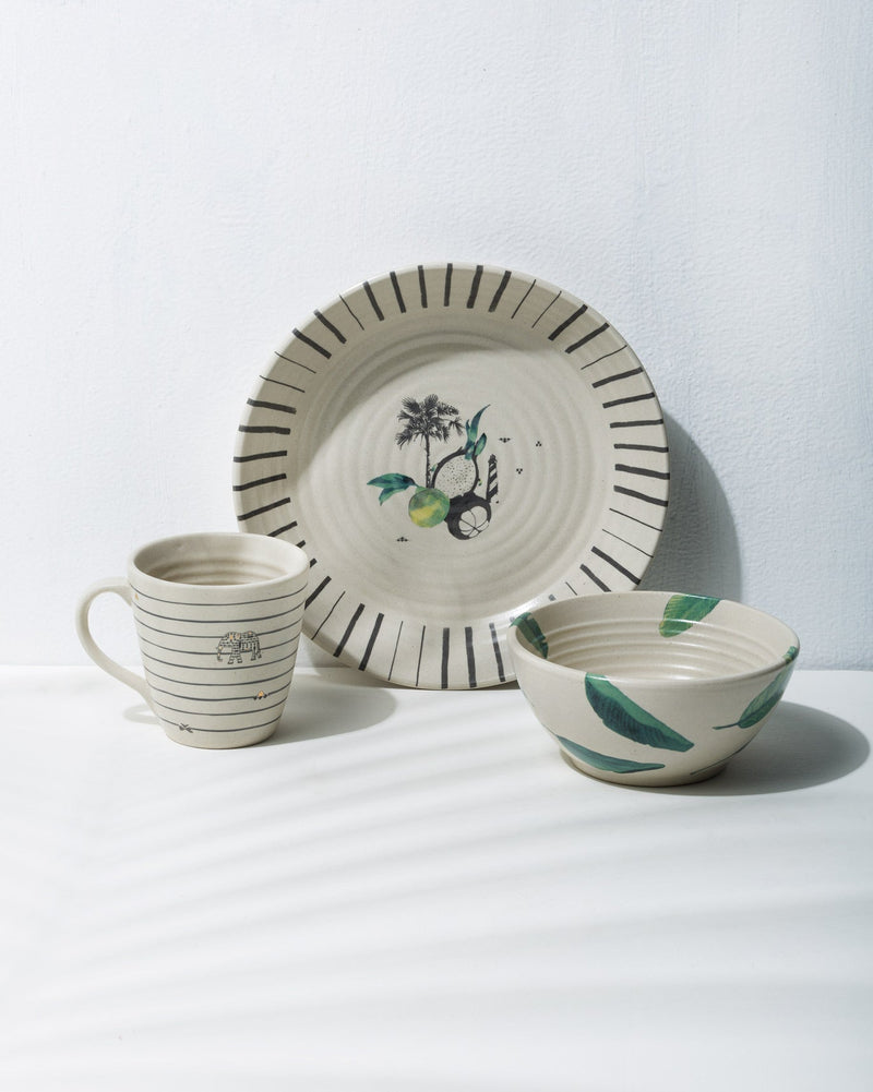 Ceylon Breakfast Set with a palm-motif plate, a striped mug and a leaf-print bowl.