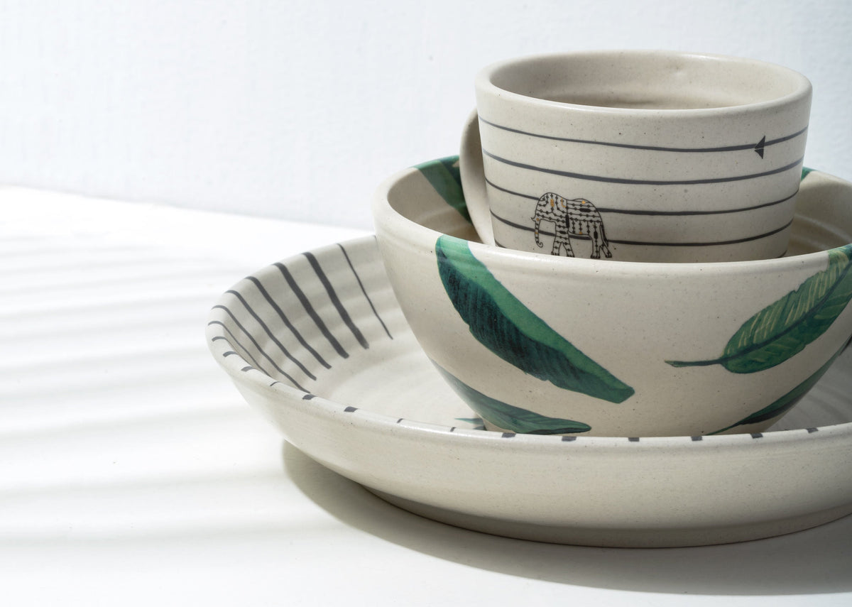 Ceylon Breakfast Set bowls and a striped plate stacked together.